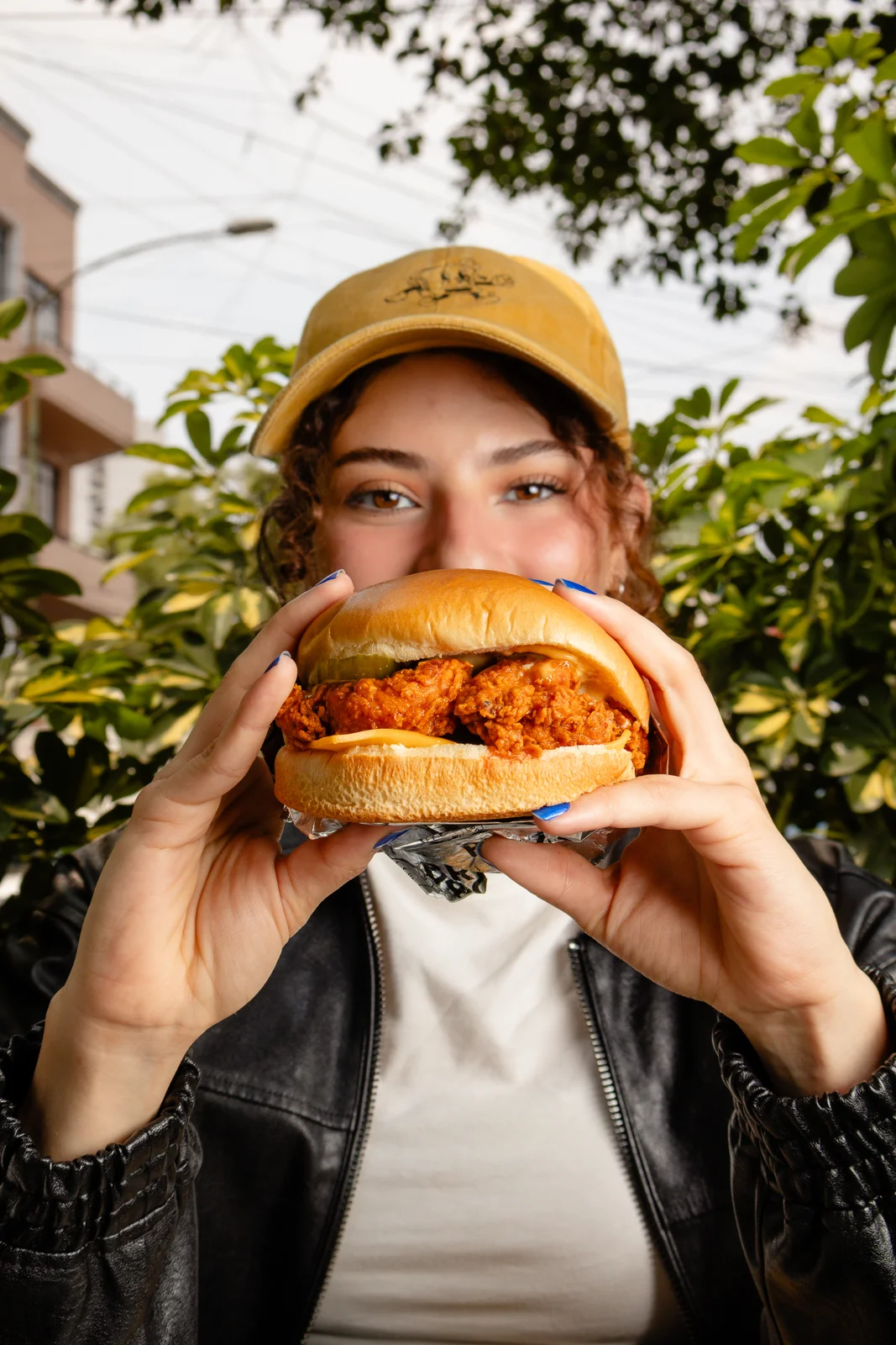 Una persona disfruta un sandwich de pollo de Bread Boss al aire libre